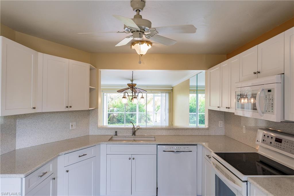 121 Gabriel Circle, Unit 1111 Naples, FL 34104 - Photo 17 of 34 a kitchen with cabinets a sink and appliances