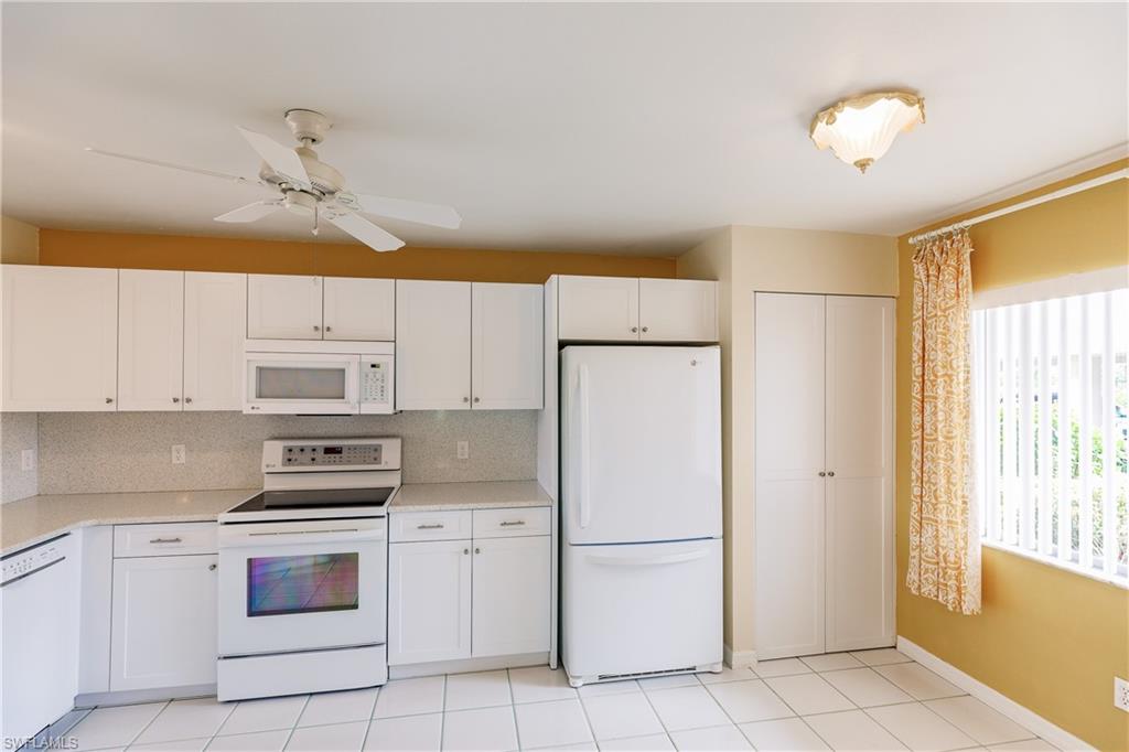 121 Gabriel Circle, Unit 1111 Naples, FL 34104 - Photo 18 of 34 a kitchen with a refrigerator a stove a microwave and cabinets