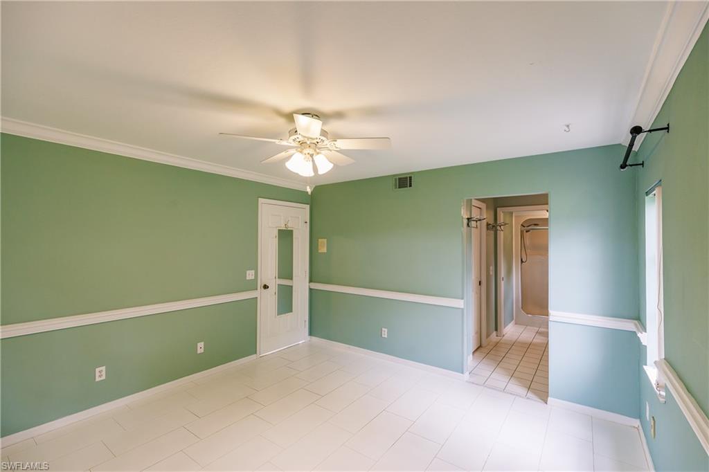 121 Gabriel Circle, Unit 1111 Naples, FL 34104 - Photo 23 of 34 a view of an empty room with window and chandelier fan