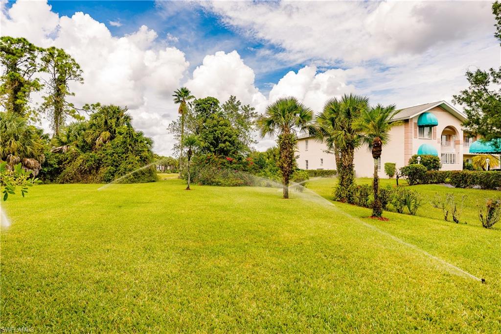 121 Gabriel Circle, Unit 1111 Naples, FL 34104 - Photo 24 of 34 a view of yard with swimming pool and green space