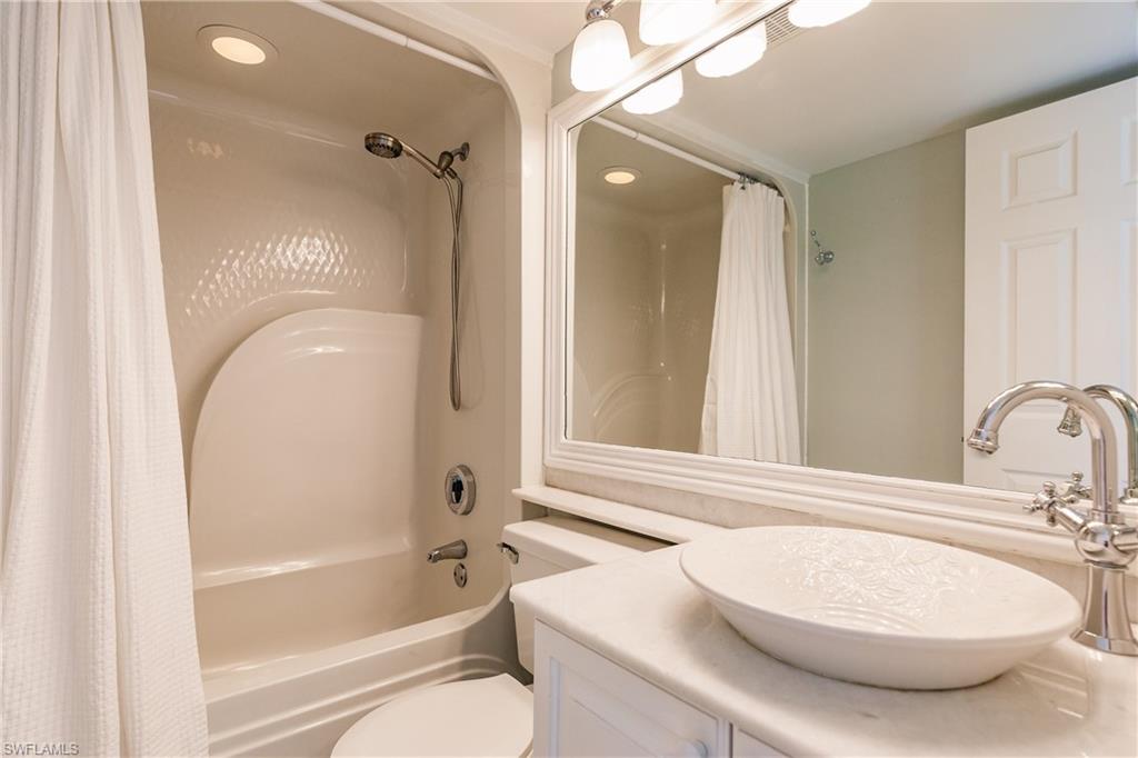 121 Gabriel Circle, Unit 1111 Naples, FL 34104 - Photo 32 of 34 a bathroom with a sink a toilet and a mirror