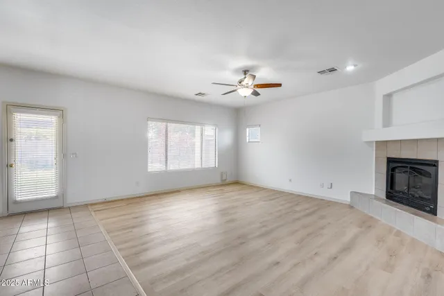 a view of an empty room with a fireplace and a window