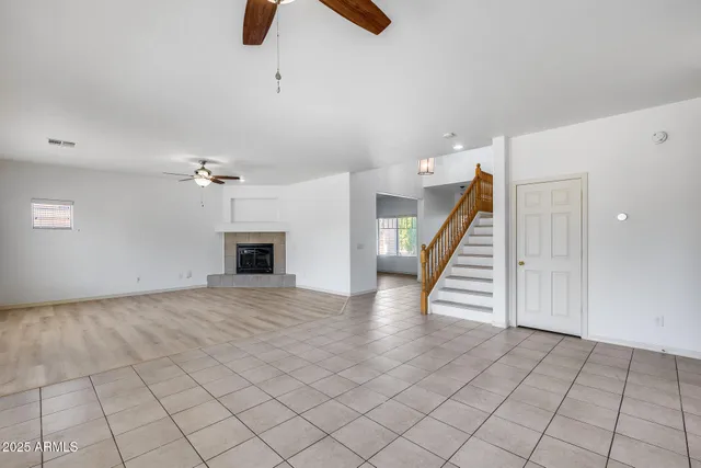 an empty room with windows and fireplace