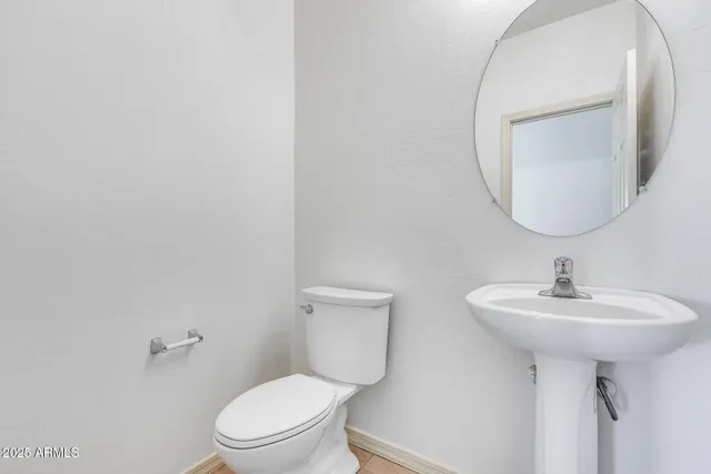 a bathroom with a sink a toilet and mirror