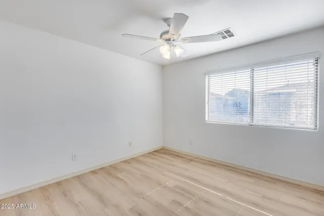 an empty room with a window and a fan