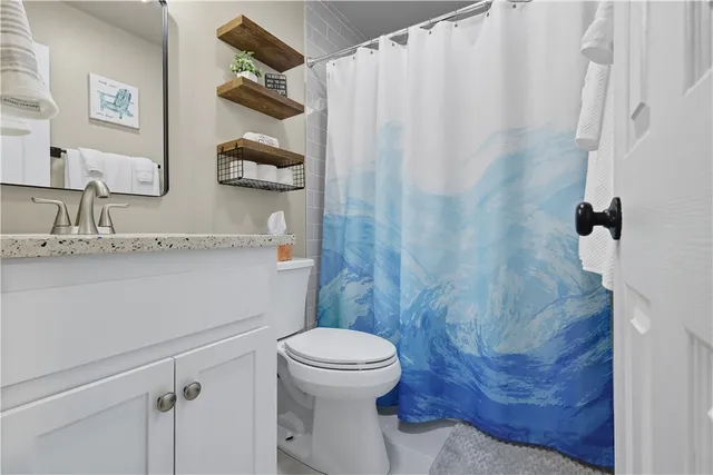 a bathroom with a granite countertop sink mirror toilet and bathtub