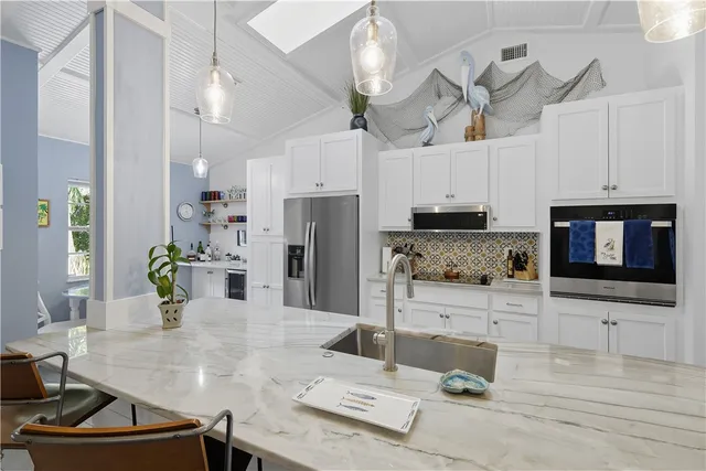 a kitchen with a sink and living room view