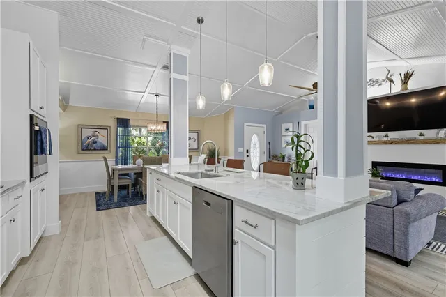 a kitchen with stainless steel appliances white cabinets and wooden floor