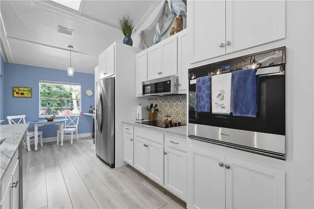 a kitchen with stainless steel appliances a refrigerator sink and wooden floor