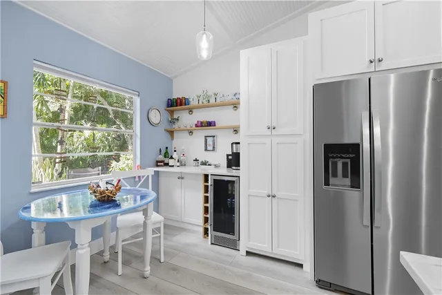 a large white kitchen with a large window and stainless steel appliances