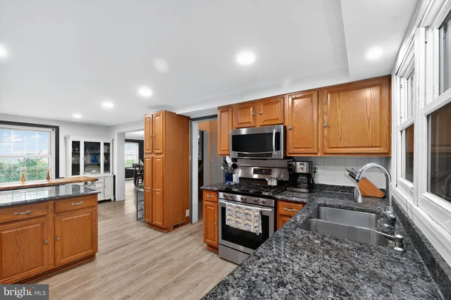 a kitchen with stainless steel appliances granite countertop counter space and wooden floor