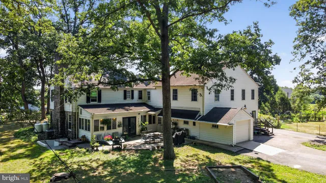 a view of a house with a big yard and large trees