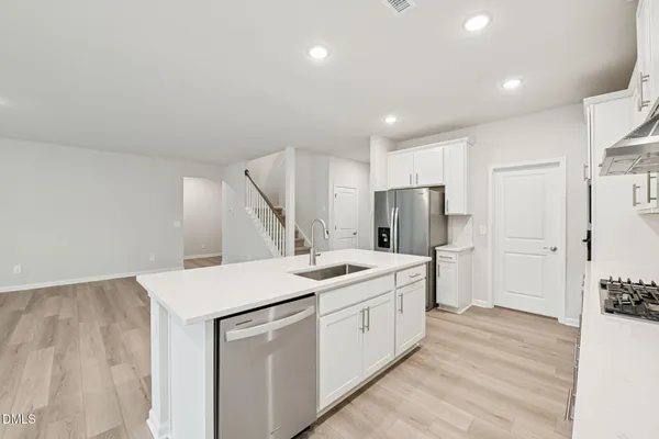 a kitchen with white cabinets and appliances