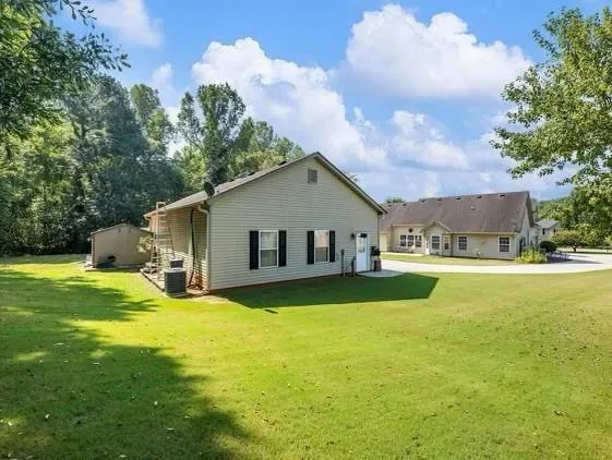 a front view of house with yard and trees in the background