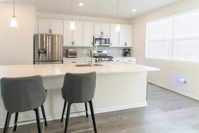 a kitchen with stainless steel appliances granite countertop a stove a sink a refrigerator and a refrigerator