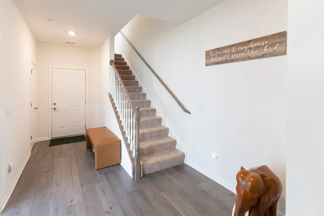 a view of entryway and hall with wooden floor