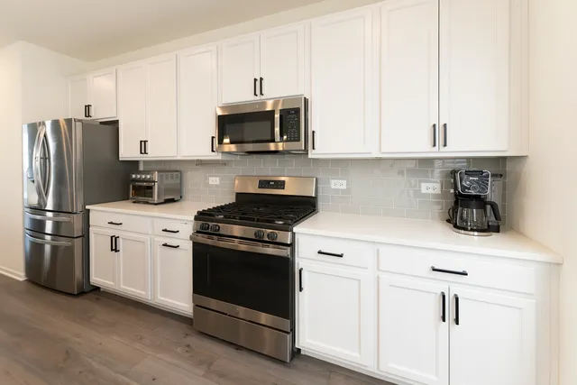 a kitchen with stainless steel appliances white cabinets and a stove