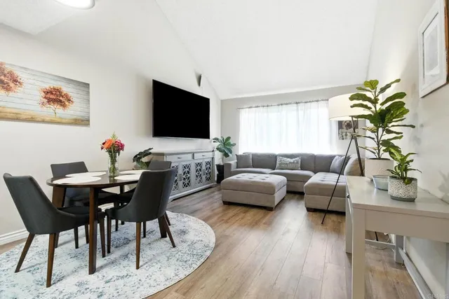 a living room with furniture floor to ceiling window and a flat screen tv