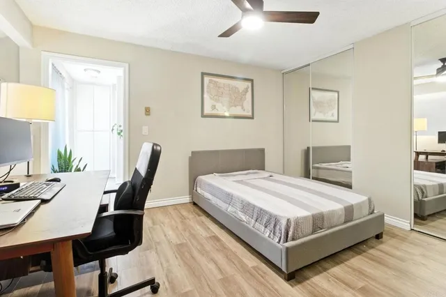 a bedroom with a bed a bookshelf and a chair