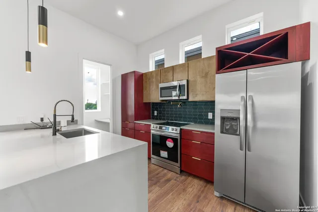 a kitchen with stainless steel appliances granite countertop a refrigerator and a stove top oven