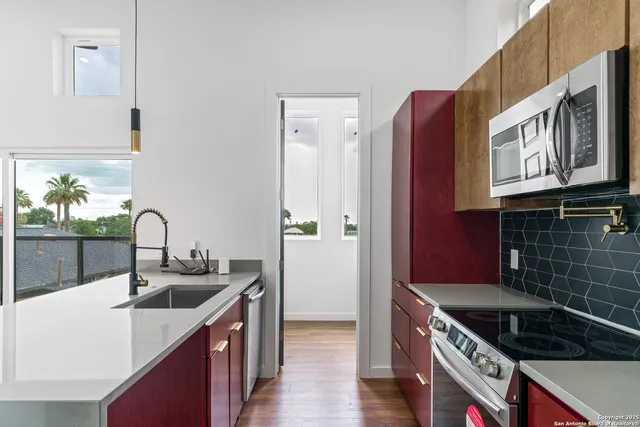 a kitchen with stainless steel appliances granite countertop a sink stove and cabinets