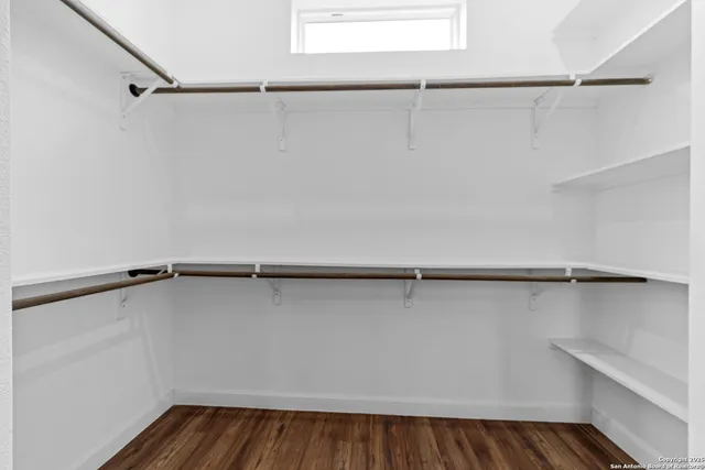 a view of walk in closet with empty racks