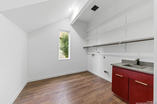 a kitchen with a sink and wooden floor