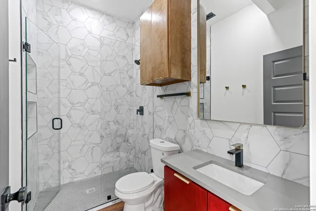 a bathroom with a sink a toilet and shower