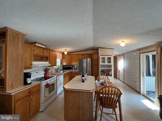 a kitchen with a sink a counter top space stainless steel appliances and cabinets