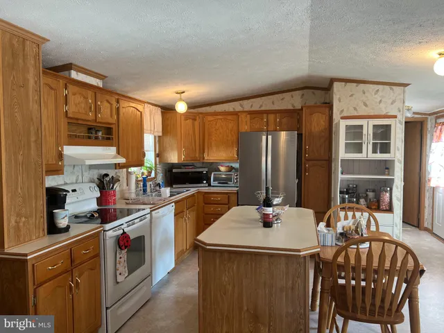 a kitchen that has a lot of cabinets a sink and appliances in it