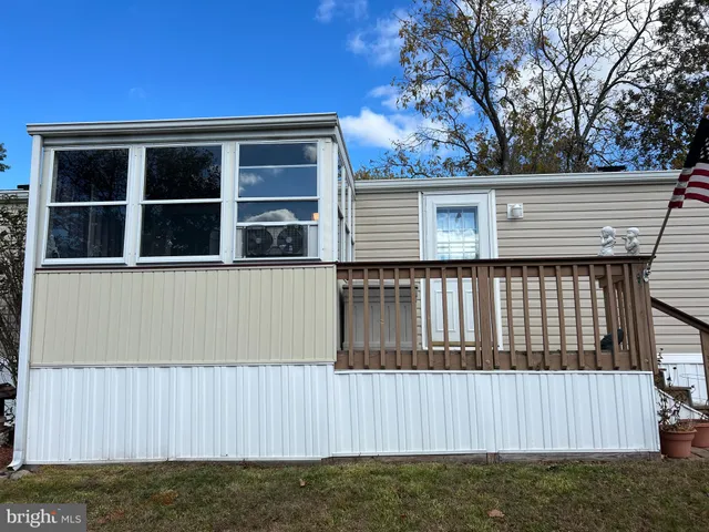 a view of a house with a large window and wooden fence
