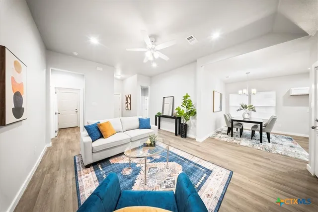 a living room with furniture and wooden floor