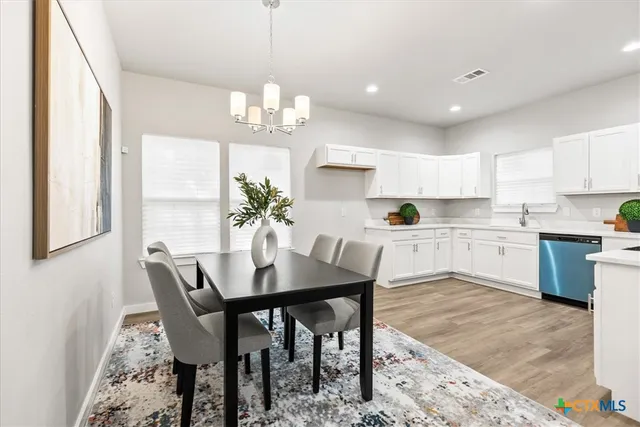 a view of a dining room with furniture and a chandelier