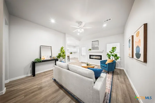 a living room with furniture a fireplace and a chandelier