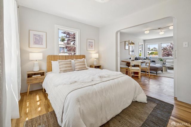 a spacious bedroom with a bed and wooden floor