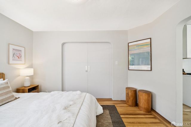 a bedroom with a bed and wooden floor