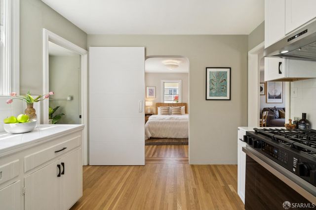a kitchen with a stove and a wooden floor
