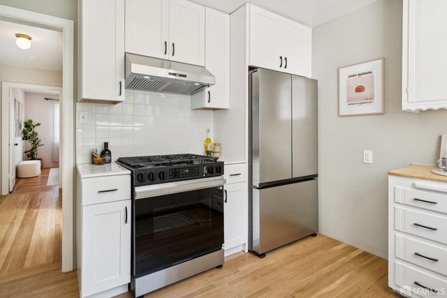 a kitchen with stainless steel appliances a stove a refrigerator and cabinets