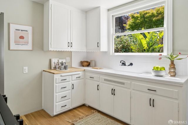 a kitchen with cabinets appliances and a window