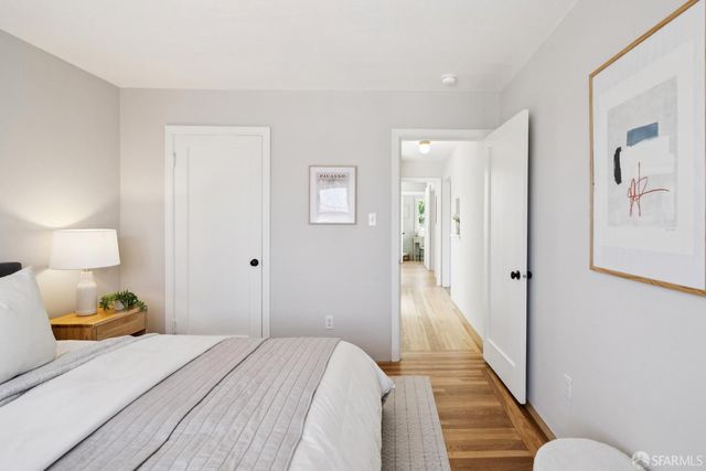 a bedroom with a bed and wooden floor