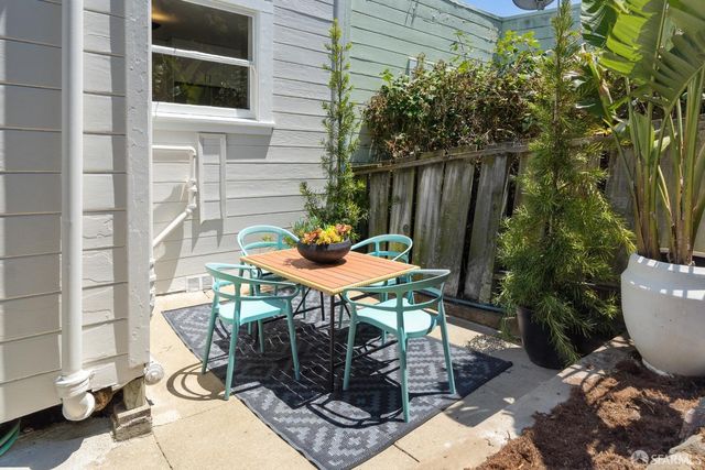 a view of a backyard with table and chairs and potted plants