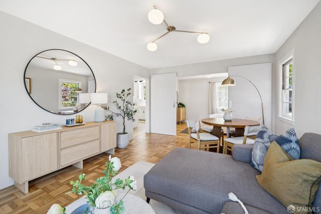 a living room with furniture a mirror and a chandelier