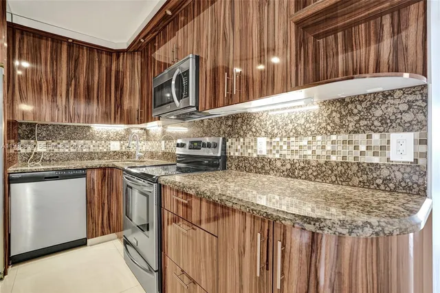 a kitchen with stainless steel appliances granite countertop a sink stove and cabinets