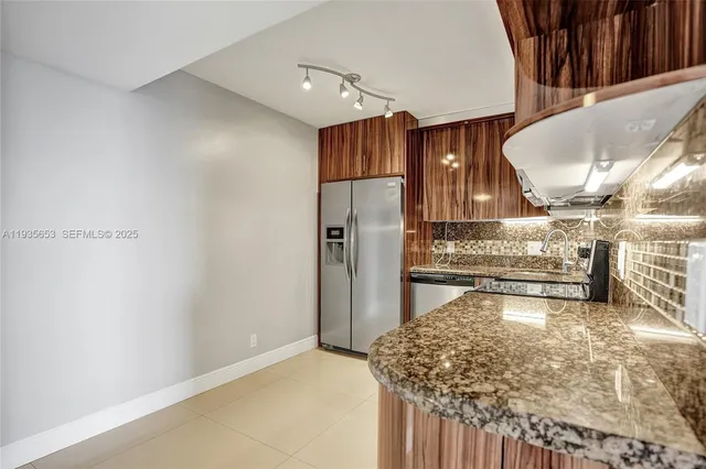 a kitchen with stainless steel appliances granite countertop a refrigerator and a sink