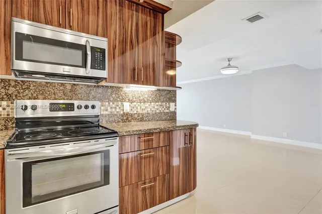 a kitchen with granite countertop cabinets stove and microwave