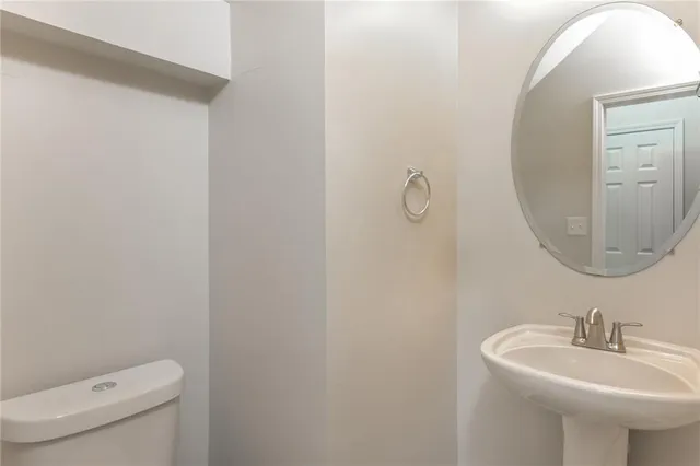 a bathroom with a sink a mirror and toilet
