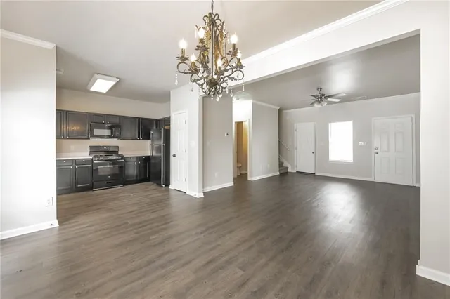 a view of a big room with wooden floor and a kitchen