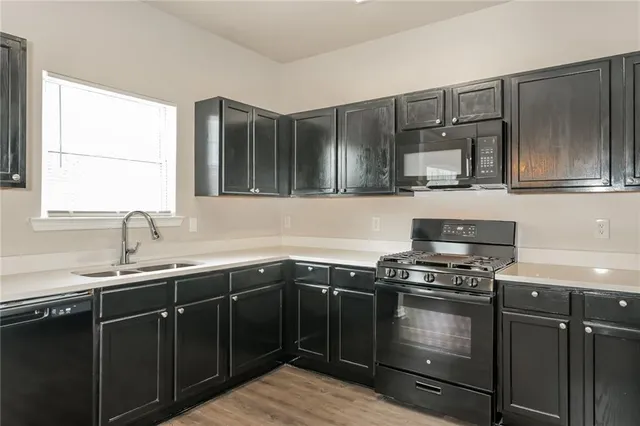 a kitchen with granite countertop a sink stove and cabinets