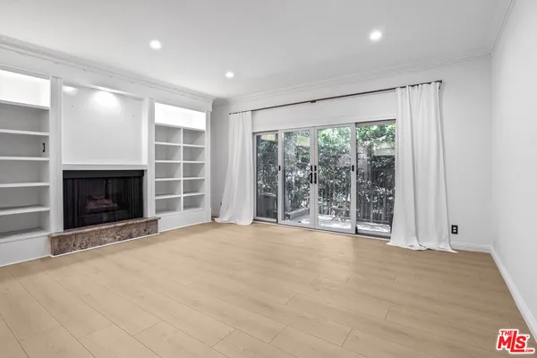 a view of an empty room with a fireplace and a window