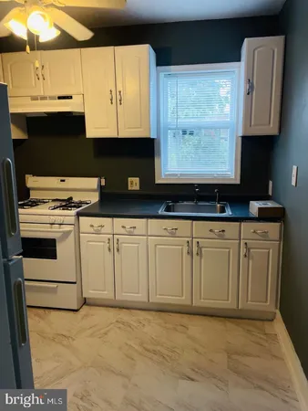 a kitchen with granite countertop a sink a stove and a microwave oven